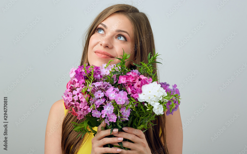 Smiling girl holding flovers in front of and looking up. Smiling girl holding flovers in front of and looking up.