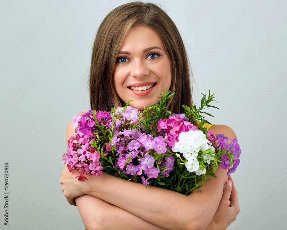 Smiling girl holding flovers in front of face. Smiling girl holding flovers in front of face.