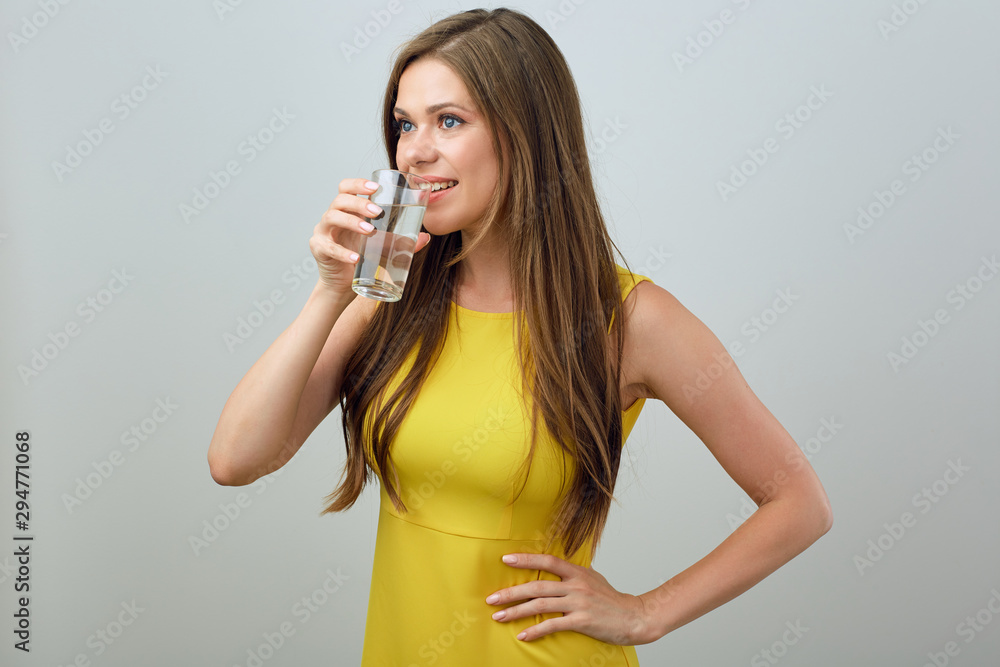 Woman in yellow dress drinking water. Woman in yellow dress drinking water.