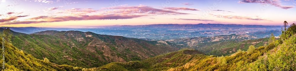 Panoramic view towards San Jose and south San Francisco bay at sunset; Hills and valleys in the Santa Cruz mountains in the foreground; Diablo Range visible on the other side of the valley, California