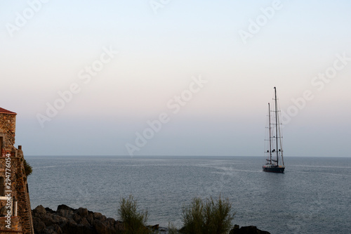 Seascape in the early morning with a yacht off the coast of Sicily. Cefalu, Italy