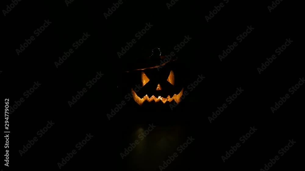 Halloween, orange pumpkin with a scary luminous face on a dark ...