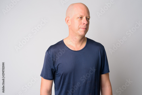 Portrait of mature handsome bald man thinking