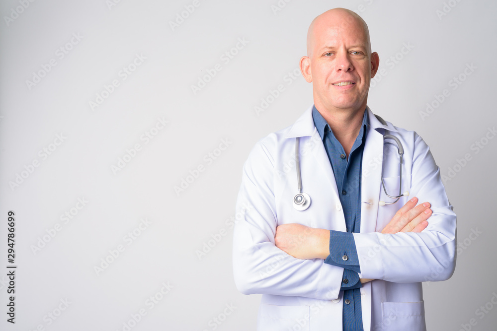 Portrait of happy mature bald man doctor smiling with arms crossed Portrait of happy mature bald man doctor smiling with arms crossed