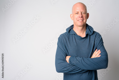 Portrait of happy mature handsome bald man smiling with arms crossed © Ranta Images