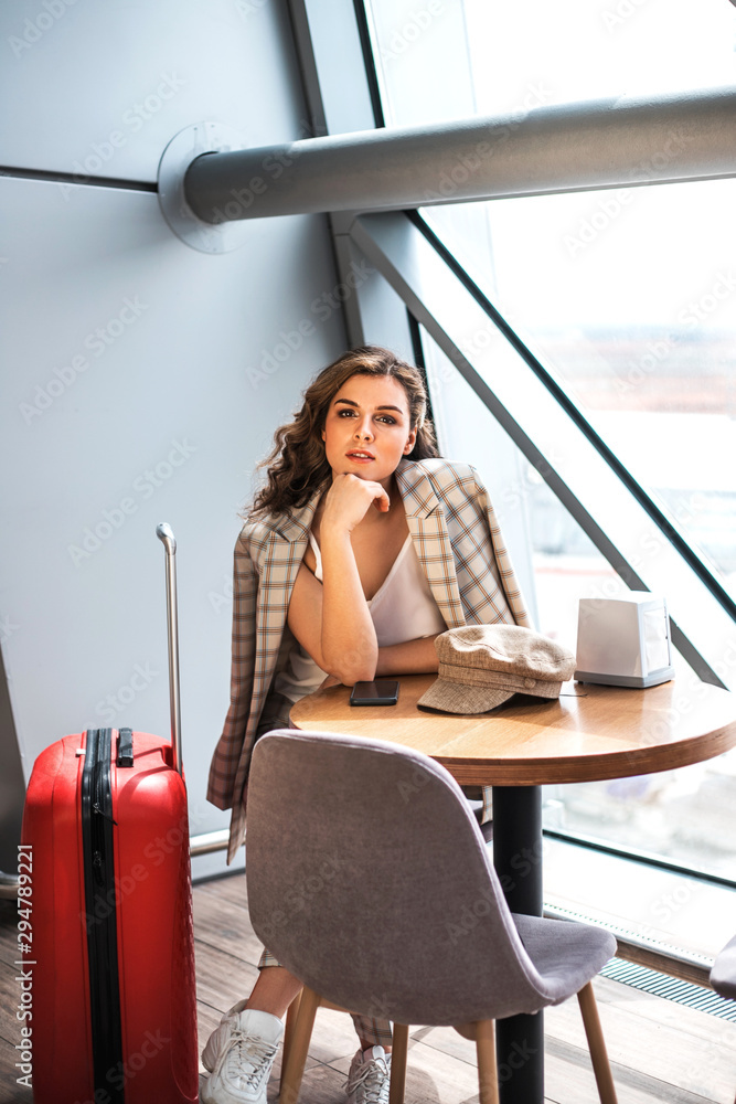 Beautiful business woman with smartphone waiting for her flight in an airport.