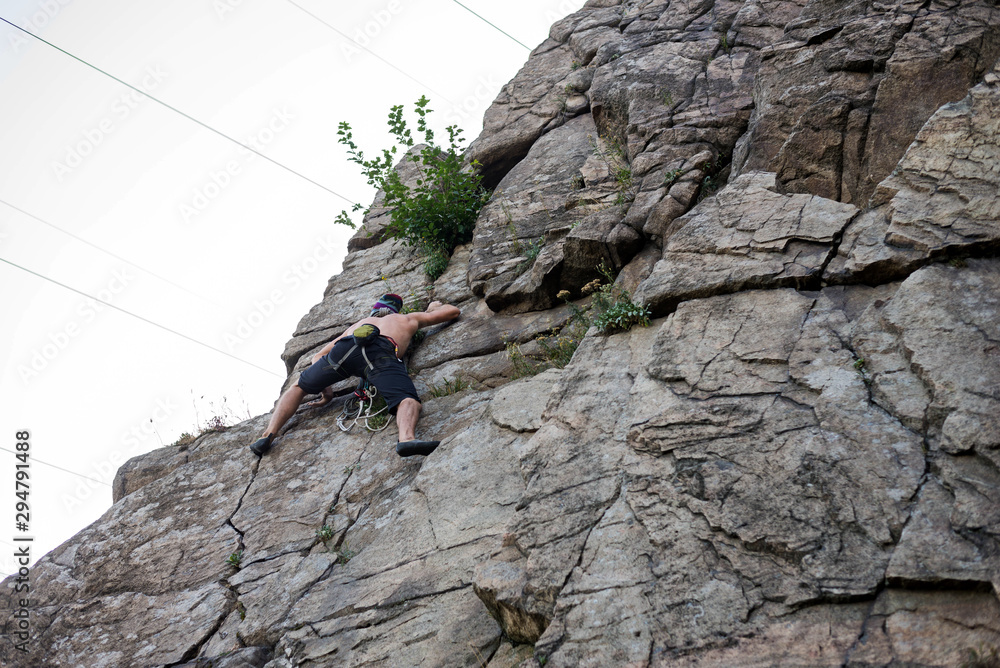 Man cliff climber is climbing a rock. Man cliff climber is climbing a rock.
