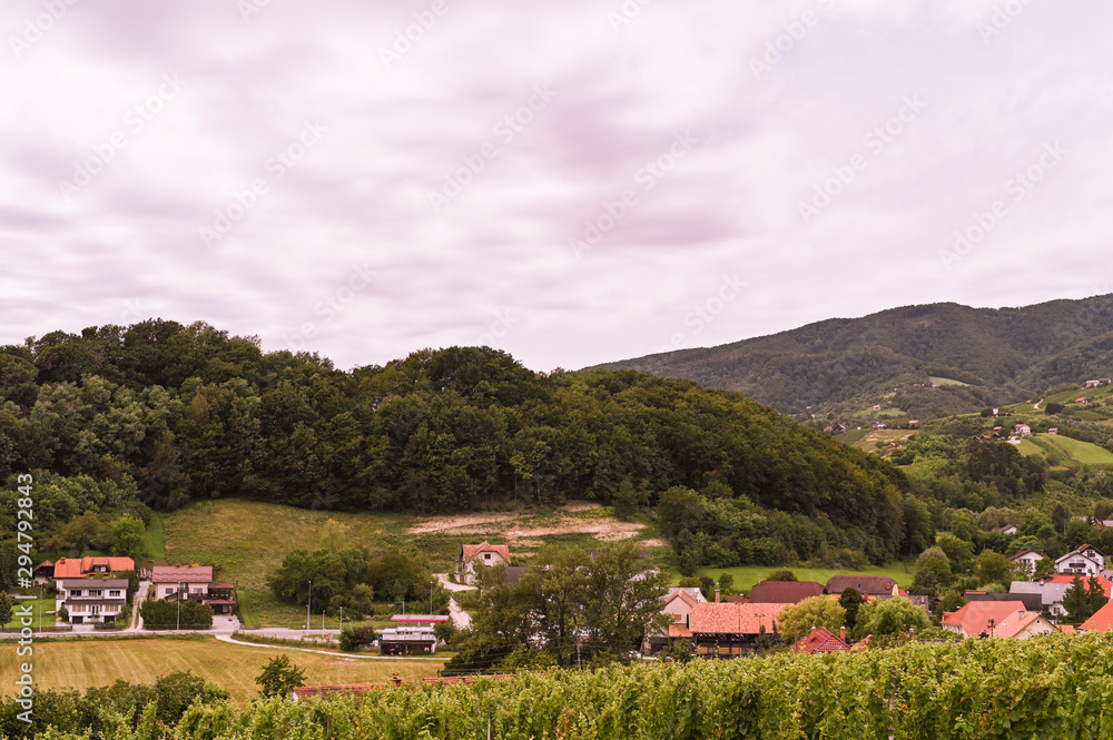 Green hills and an old village in Slovenia. Traveling in Europe and tourism. Nature, sky and vineyards.