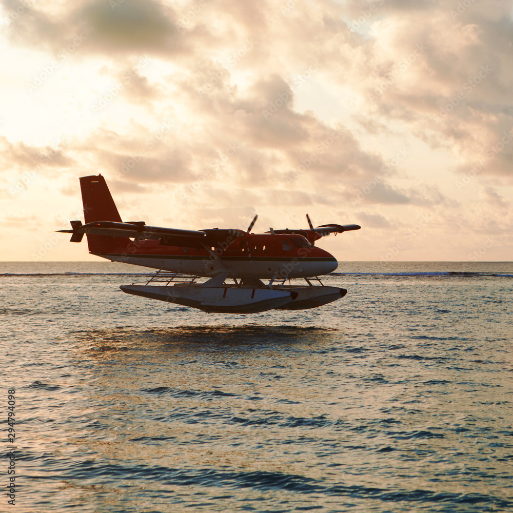 Summer sunset with seaplane. Landing seaplane on the dawn seashore. Calm scenery on evening sea. Summer sunset with seaplane. Landing seaplane on the dawn seashore. Calm scenery on evening sea.