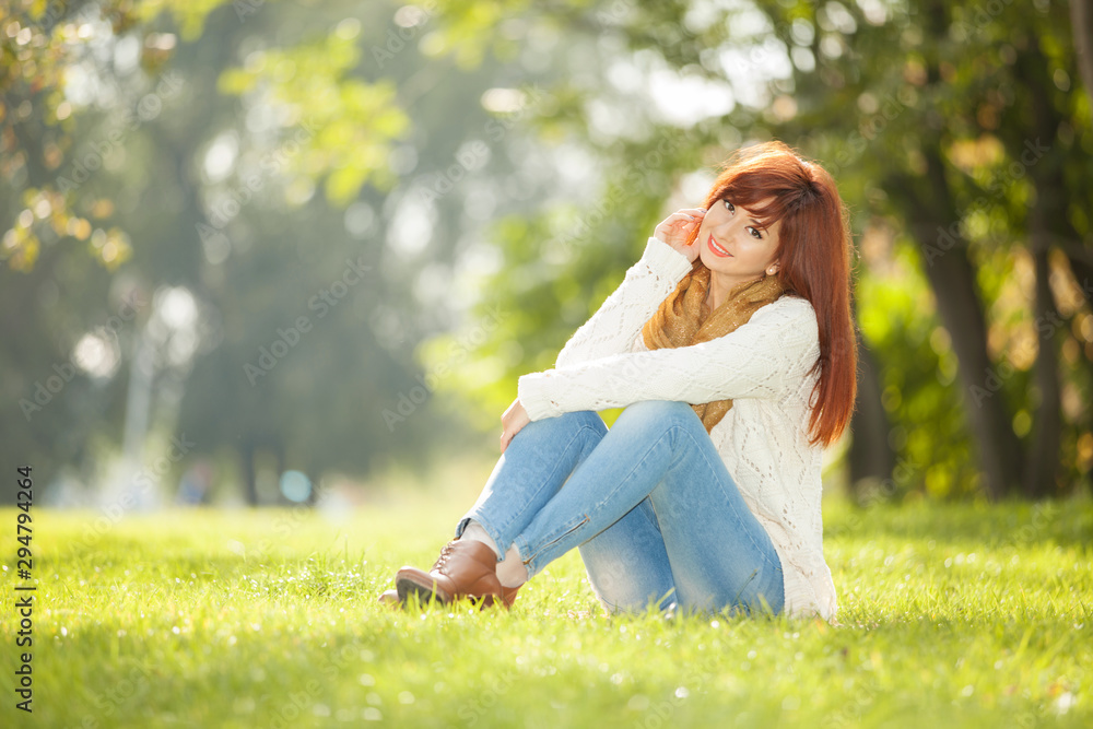 Obraz premium Young woman walking in the park. Beauty nature scene with colorful background at autumn season. Outdoor lifestyle. Happy smiling woman relax at fall