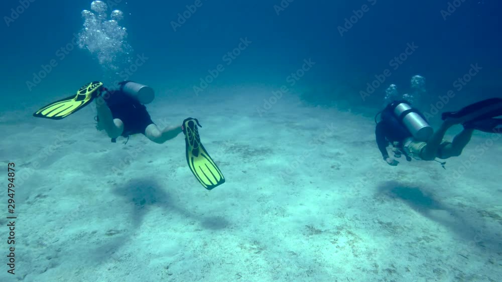 Scuba Diver Closes In On Two other Divers From Behind Over a Barren Ocean Floor in Siargao Island, Philippines Scuba Diver Closes In On Two other Divers From Behind Over a Barren Ocean Floor in Siargao Island, Philippines