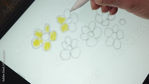 Woman colouring a picture on a graphic tablet with special pen. Relax concept. 