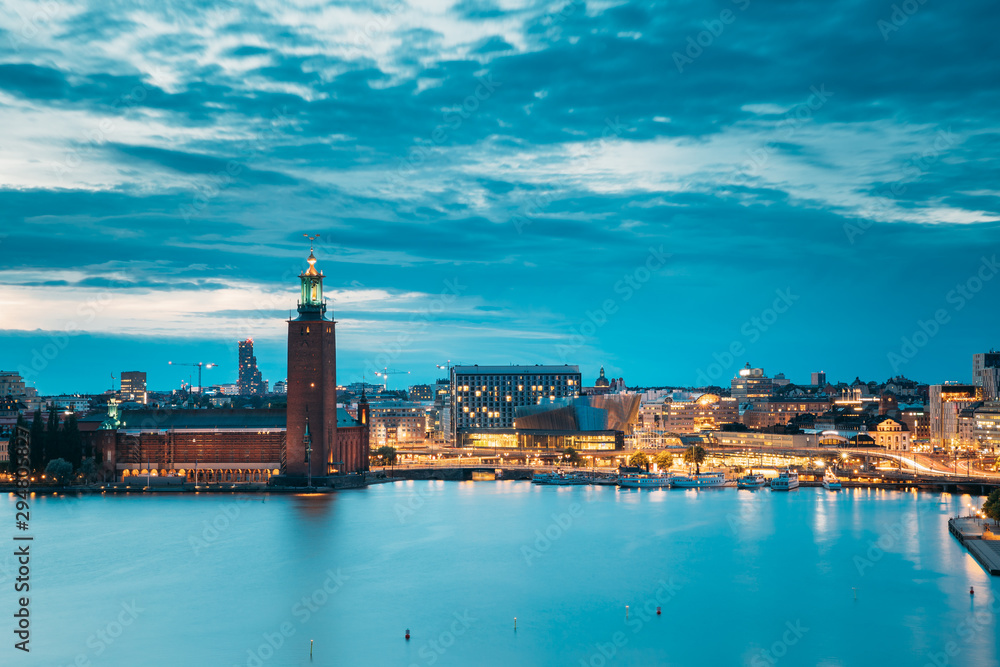 Stockholm, Sweden. Scenic Skyline View Of Famous Tower Of Stockholm City Hall. Building Of Municipal Council. Famous Popular Destination Place In Dusk Lights. Night Lighting Stockholm, Sweden. Scenic Skyline View Of Famous Tower Of Stockholm City Hall. Building Of Municipal Council. Famous Popular Destination Place In Dusk Lights. Night Lighting
