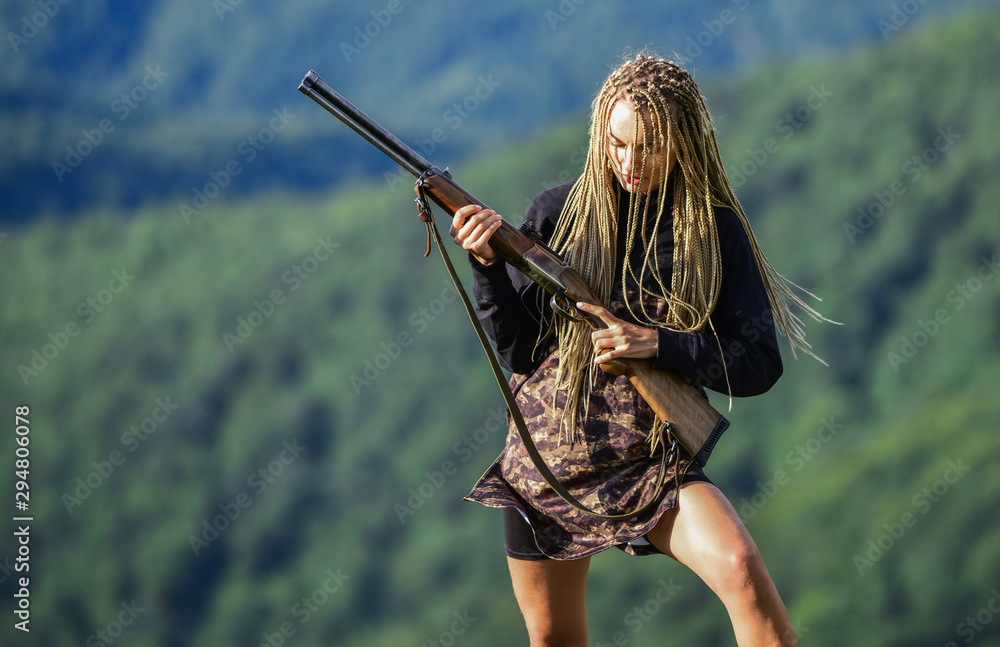 Hunting season. Sexy warrior. She is warrior. Woman attractive long hair pretty face hold rifle for hunting. Dangerous girl. Defending concept. Warrior mountains landscape background. Feminist girl
