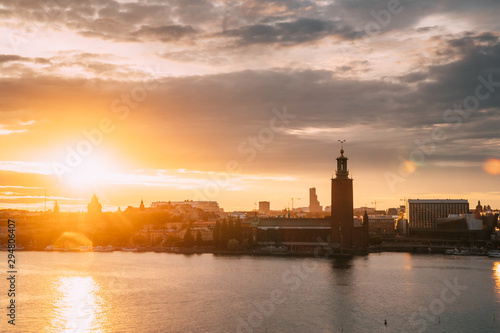 Stockholm, Sweden. Scenic Skyline View Of Famous Tower Of Stockholm City Hall. Building Of Municipal Council Stands On Kungsholmen Island. Sunshine Above Famous And Popular Place In Sunset Sunrise