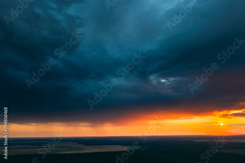 Aerial View Of Sunset Sky Above Green Forest Landscape In Evening. Top View From High Attitude In Summer Sunrise