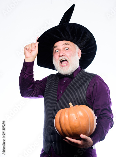 Halloween is a real treat. Stargazer in holiday costume. Traditional food. evil wizard hold orange pumpkin. happy halloween. bearded man ready for halloween party. mature man magician in witch hat photo