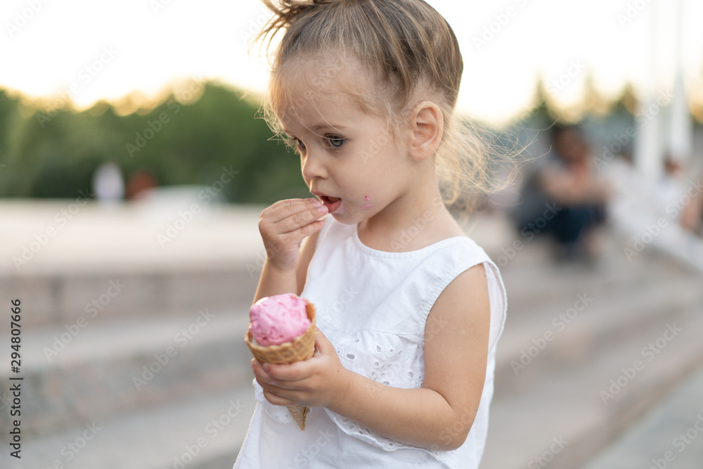 Little caucasian girl 3 years old eats ice cream closeup portrait Little caucasian girl 3 years old eats ice cream closeup portrait