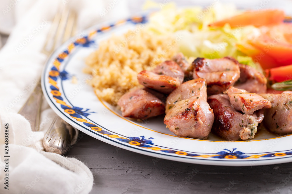 fried meat with quinoa and fresh salad on plate on ceramic background fried meat with quinoa and fresh salad on plate on ceramic background