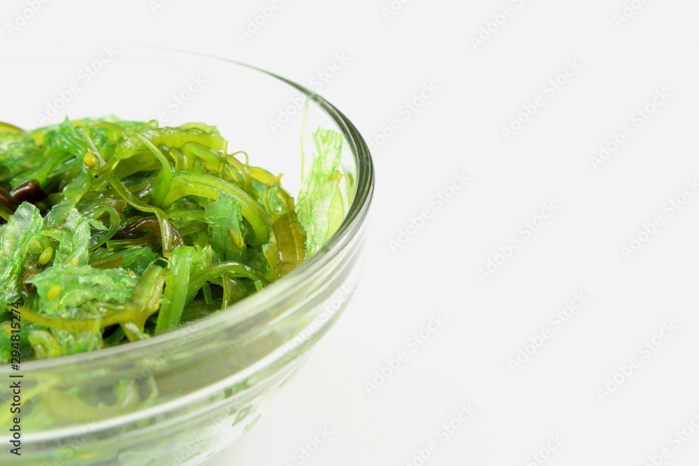 wakame salad with sesame in a small glass bowl isolated wakame salad with sesame in a small glass bowl isolated