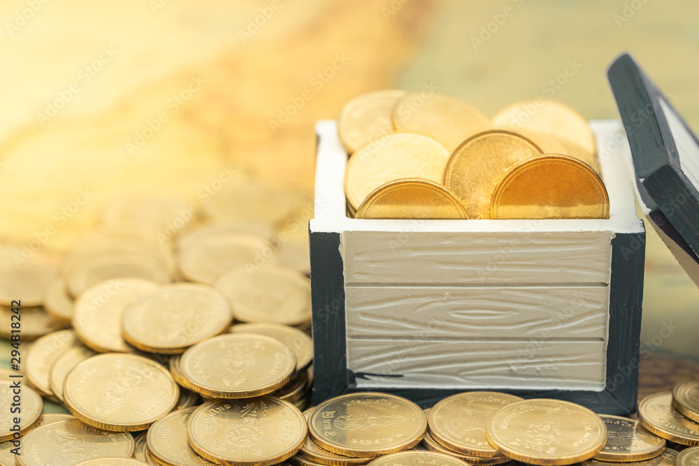 Gold coins in opened white treasure chest on ancient map. For business achievement concept