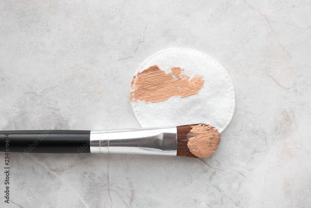 Make up brush and cotton round with BB cream or foundation on luxury marble  background, top view. Daily makeup Stock Photo | Adobe Stock