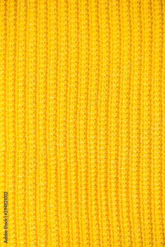 Yellow orange mustard ochre knitting wool texture background.Winter or autumn sweater or jumper with buttons close-up.Vertical orientation,flat lay,top view