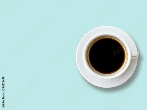 Top view of Black coffee in white cup isolated on the pastel blue background. Copy space and pastel concept.