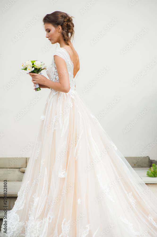Beautiful happy bride in long wedding dress with wedding bouquet Beautiful happy bride in long wedding dress with wedding bouquet