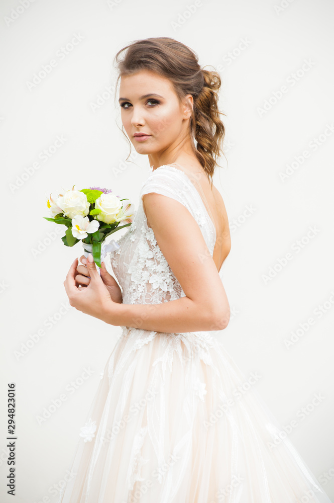 Bride in long wedding dress with bouquet outdoor