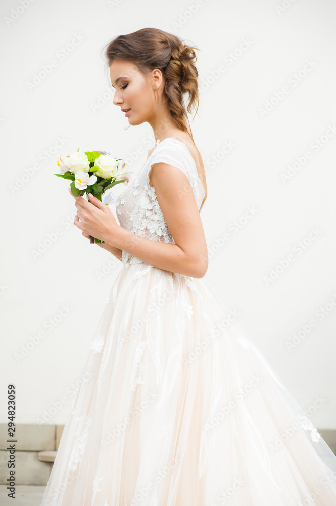 Beautiful bride holding a bouquet before getting married Beautiful bride holding a bouquet before getting married