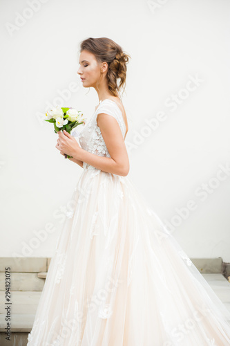 Bride in long wedding dress with bouquet outdoor