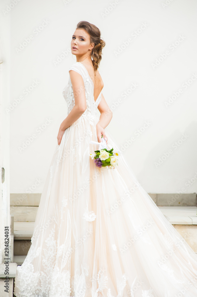 Beautiful happy bride in long wedding dress with wedding bouquet Beautiful happy bride in long wedding dress with wedding bouquet