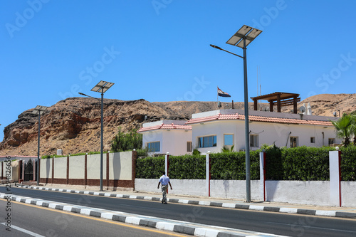 View of production alternative energy. Solar powered lamps. Scenic road with solar panels on a sunny day.