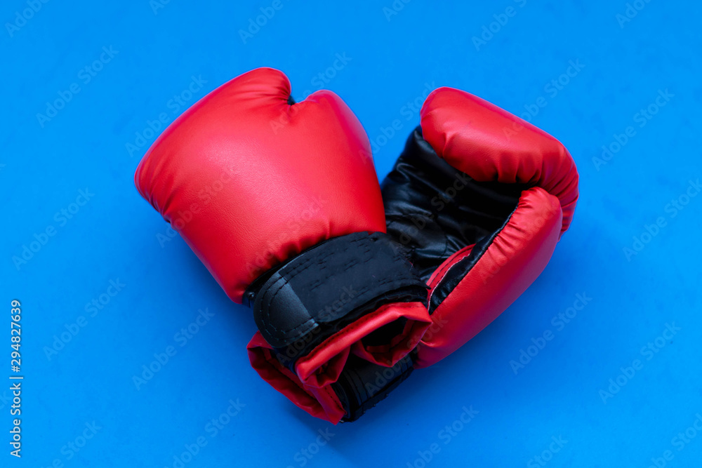 Red boxing gloves on a blue background