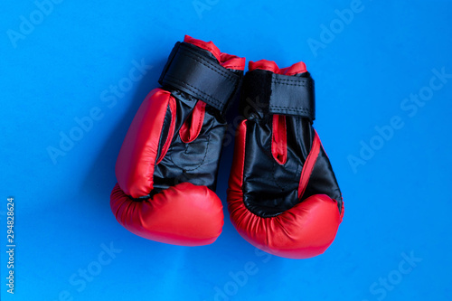 Red boxing gloves on a blue background