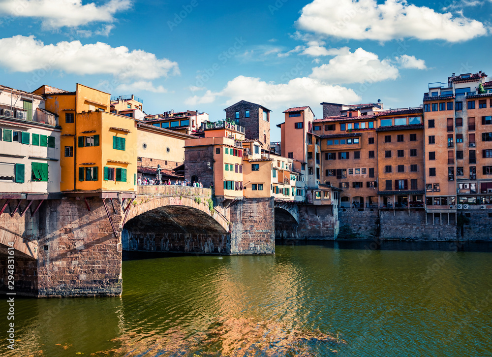 Picturesque medieval arched river bridge with Roman origins - Ponte Vecchio over Arno river. Colorful spring morning view of Florence, Italy, Europe. Traveling concept background.