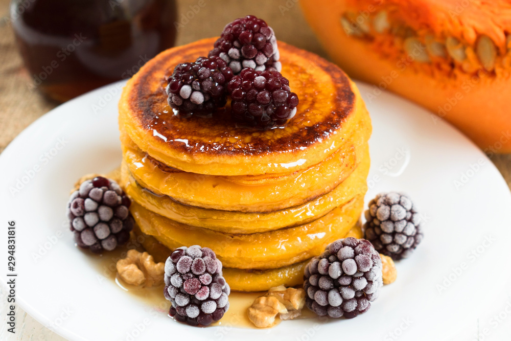 Pumpkin pancakes with maple syrup, berries and nuts. End of seasonal (autumn) breakfast. Pumpkin pancakes with maple syrup, berries and nuts. End of seasonal (autumn) breakfast.