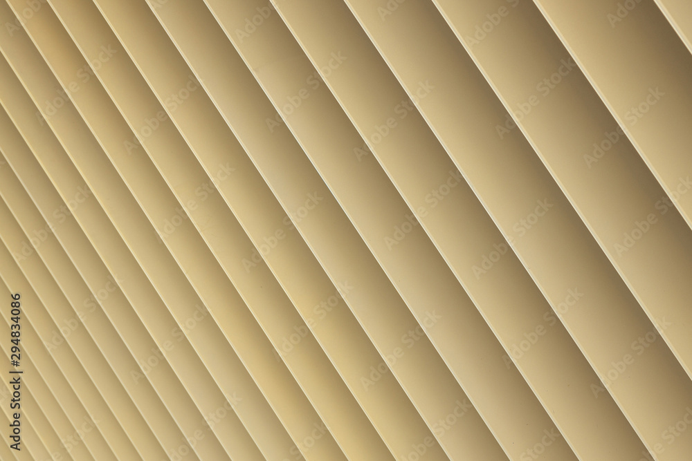 Obraz premium Diagonal view of beige or golden 3d stripes. Louvre shutters like pattern, diagonal pattern close-up.