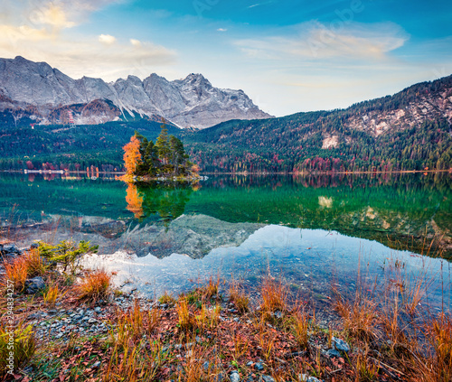 Colorful morning scene of Eibsee lake with Zugspitze mountain range on background. Amazing autumn view of Bavarian Alps, Germany, Europe. Beauty of nature concept background.