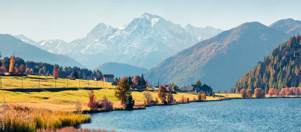 Fototapeta premium Panoramic autumn scene of Haidersee (Lago della Muta) lake with Ortler peak on background. Splendid morning view of Italian Alps, Italy, Europe.Beauty of nature concept background.