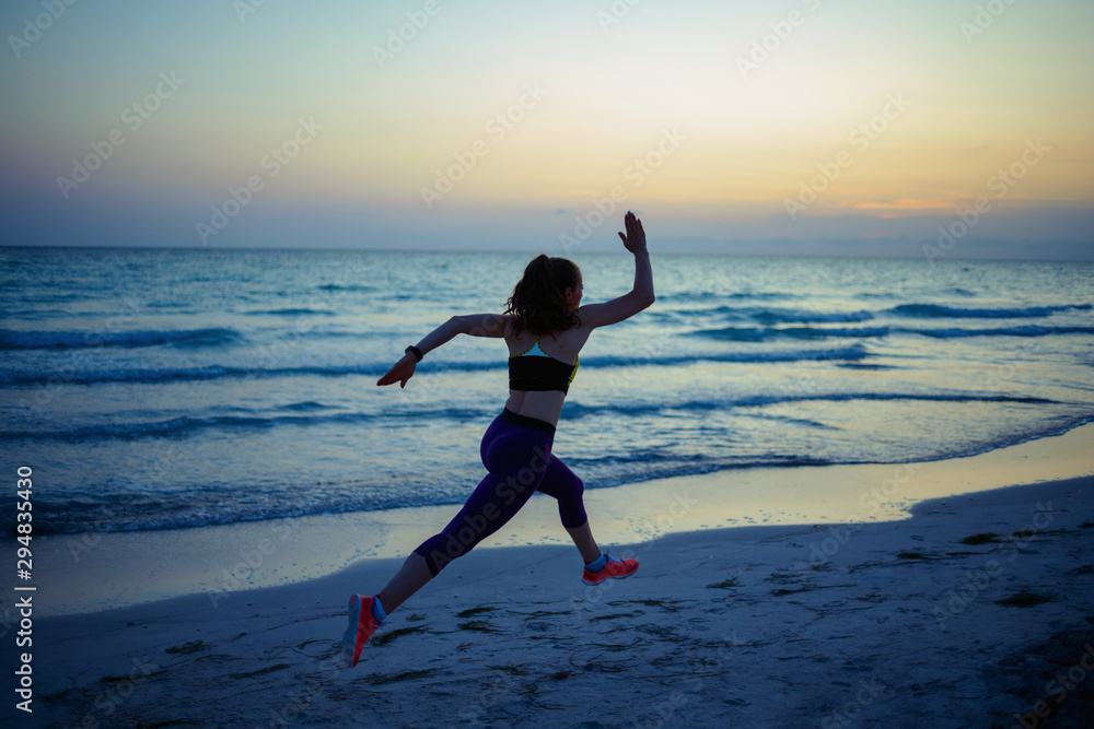 fit sports woman on ocean shore in evening jogging fit sports woman on ocean shore in evening jogging