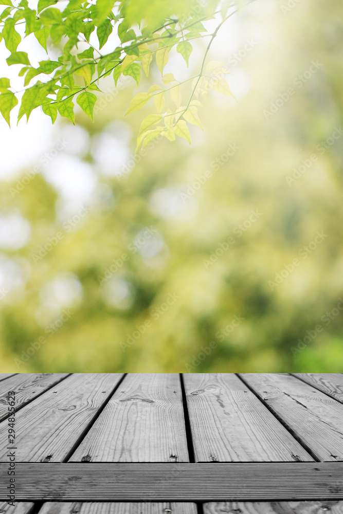 Wooden table and blurred green leaves nature bokeh background. Wooden table and blurred green leaves nature bokeh background.