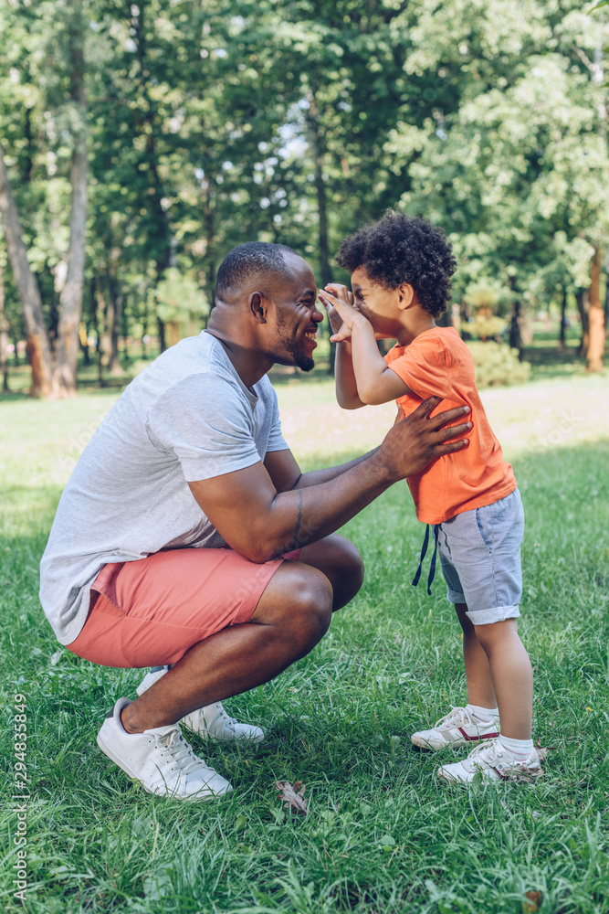 cheerful african american boy having fun with happy father in park cheerful african american boy having fun with happy father in park