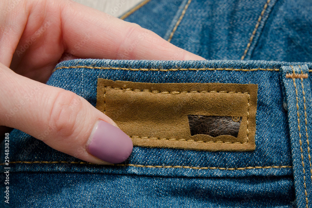 KHARKOV, UKRAINE - 02 MARCH 2018: Lather label Levis on jeans in female  hand Stock Photo | Adobe Stock