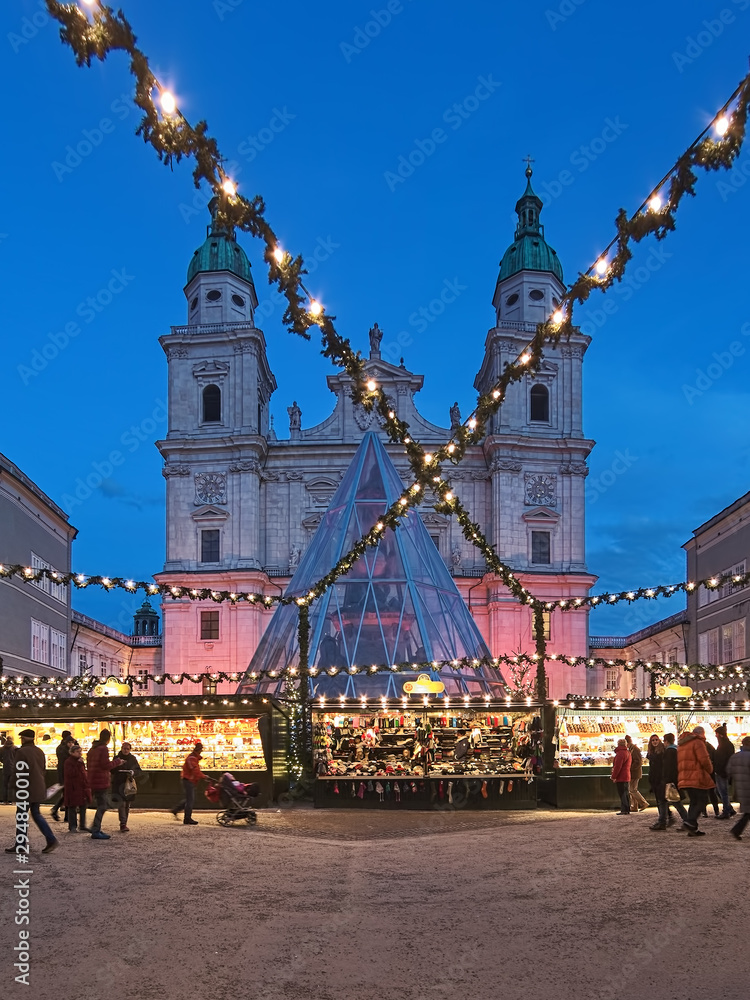 Fototapeta premium Salzburg, Austria. Christmas market at the Domplatz (Cathedral Square) in front of Salzburg Cathedral in twilight.