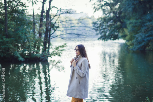 portrait of a fashionable beautiful woman in a coat near the river © jozzeppe777