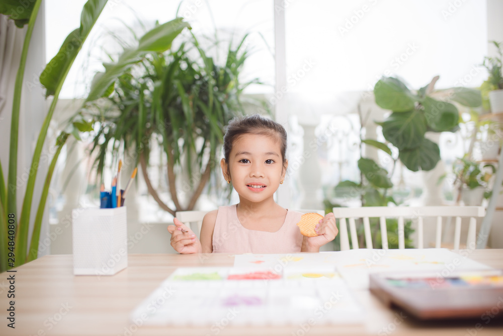 Cute little girl painting picture on home interior background Cute little girl painting picture on home interior background