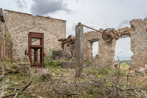 Old and ruined olive oil factory in abandoned village Palia Plagia, Greece photo