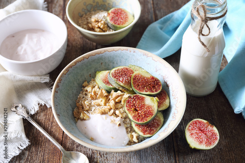 Healthy breakfast: oatmeal, yogurt, ripe figs, walnuts and milk